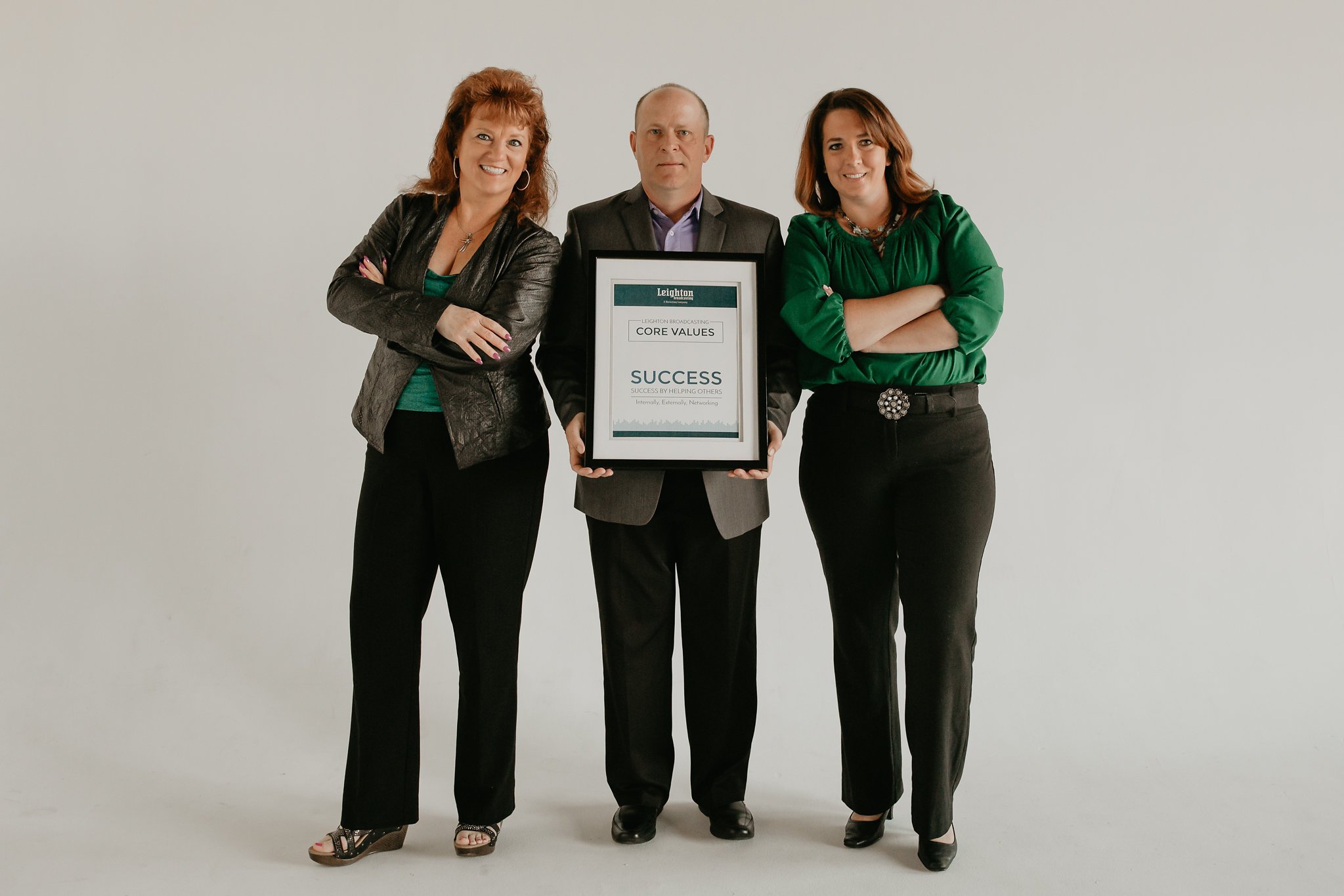 Image of three people standing with an award
